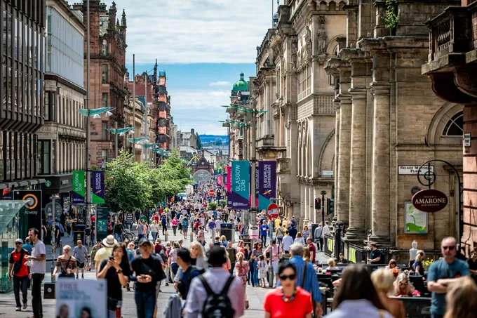 Ihmisiä kävelemässä vanhojen kivirakennusten reunustamalla kävelykadulla Glasgow'ssa.